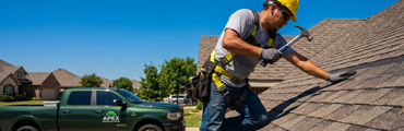 Man on a roof installing a shingle